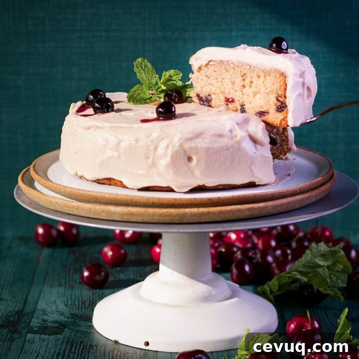 Lifting a slice from a cherry cake covered in cherry frosting.