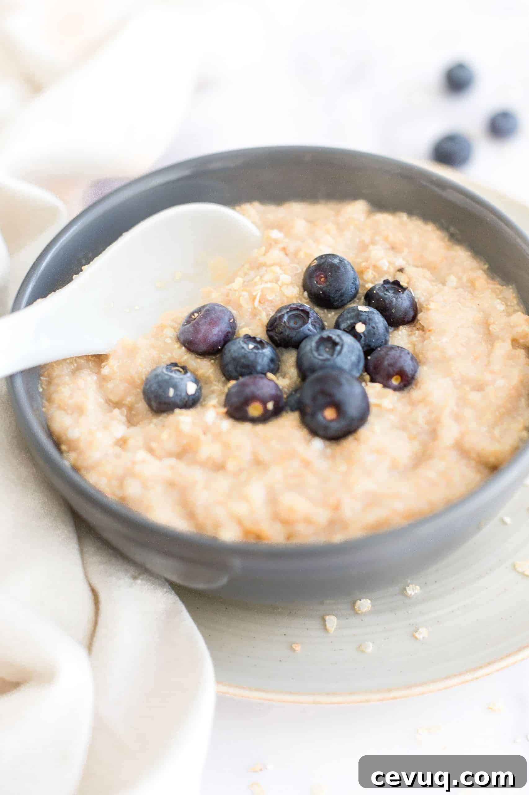 5-Minute Creamy Quinoa Oatmeal (Gluten-Free, Vegan) Up close shot of quinoa porridge in a gray bowl.