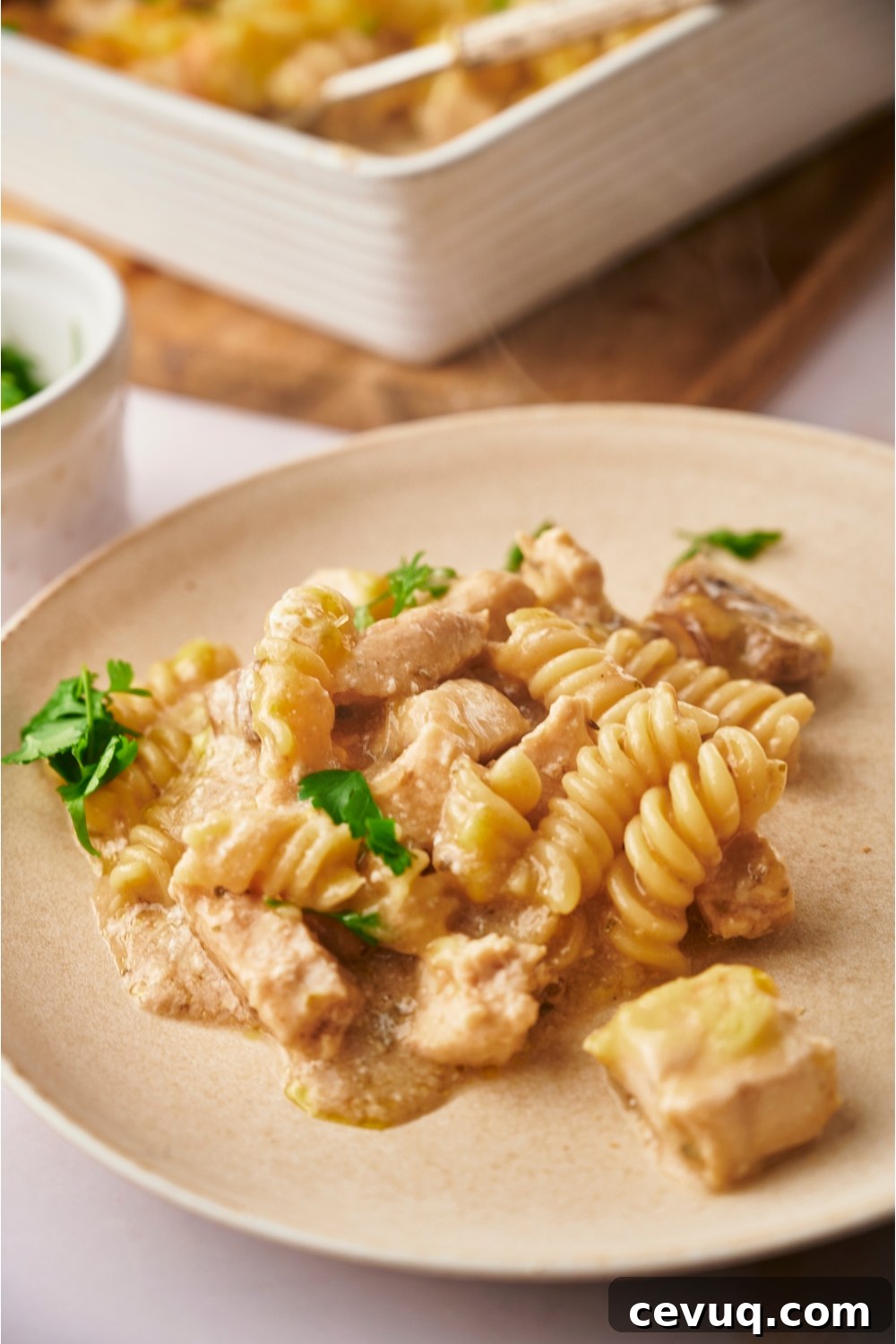A serving of chicken and mushroom casserole on an off-white plate.