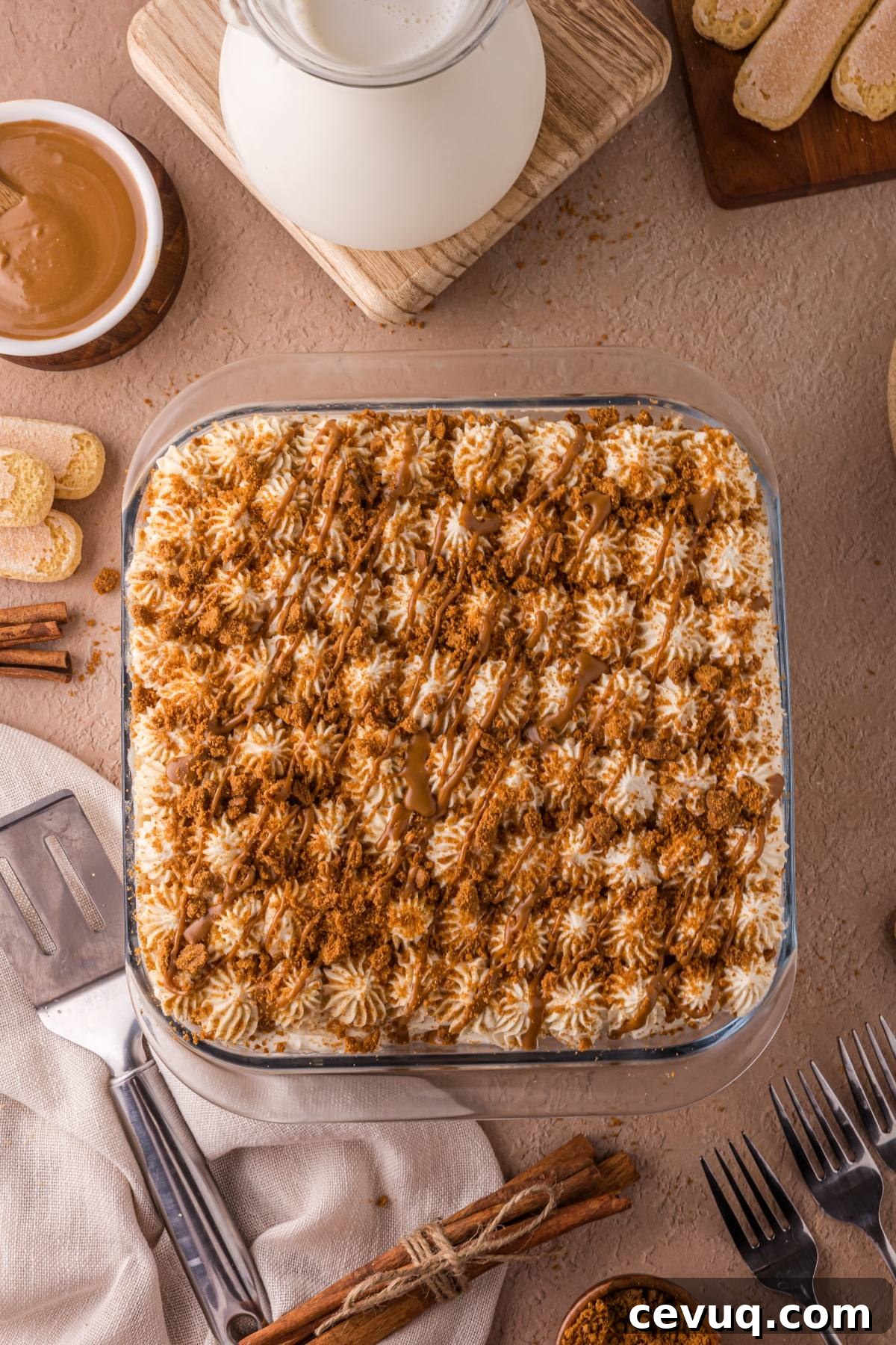 A square Biscoff tiramisu dessert topped with cream, crumbs, and drizzle.