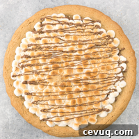 S'mores Dessert Pizza Recipe: Gooey Chocolate and Marshmallow Pie 5 Soft & Gooey Loaded S’mores Pizza or S’mores Pie - flavored with crushed graham crackers cookie dough, and layered with marshmallow and sweet chocolate chips. Who needs a campfire? Bake this indoor rich, gooey S’mores cake instead! Loads of s’mores in every bite! So good! Quick and easy recipe.