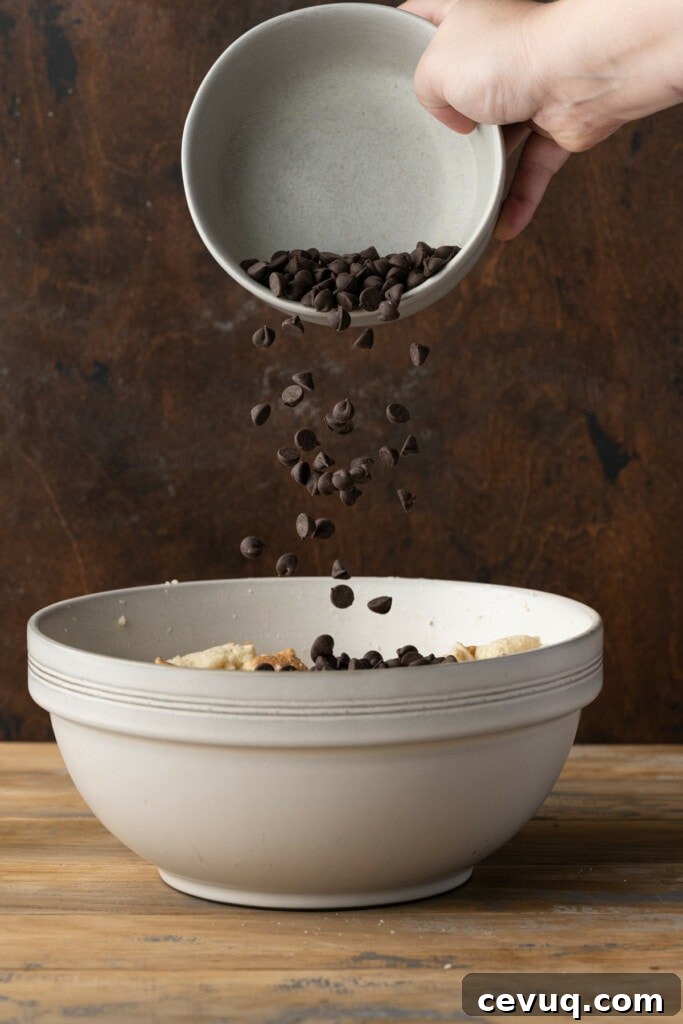Adding chocolate chips to bread pudding.
