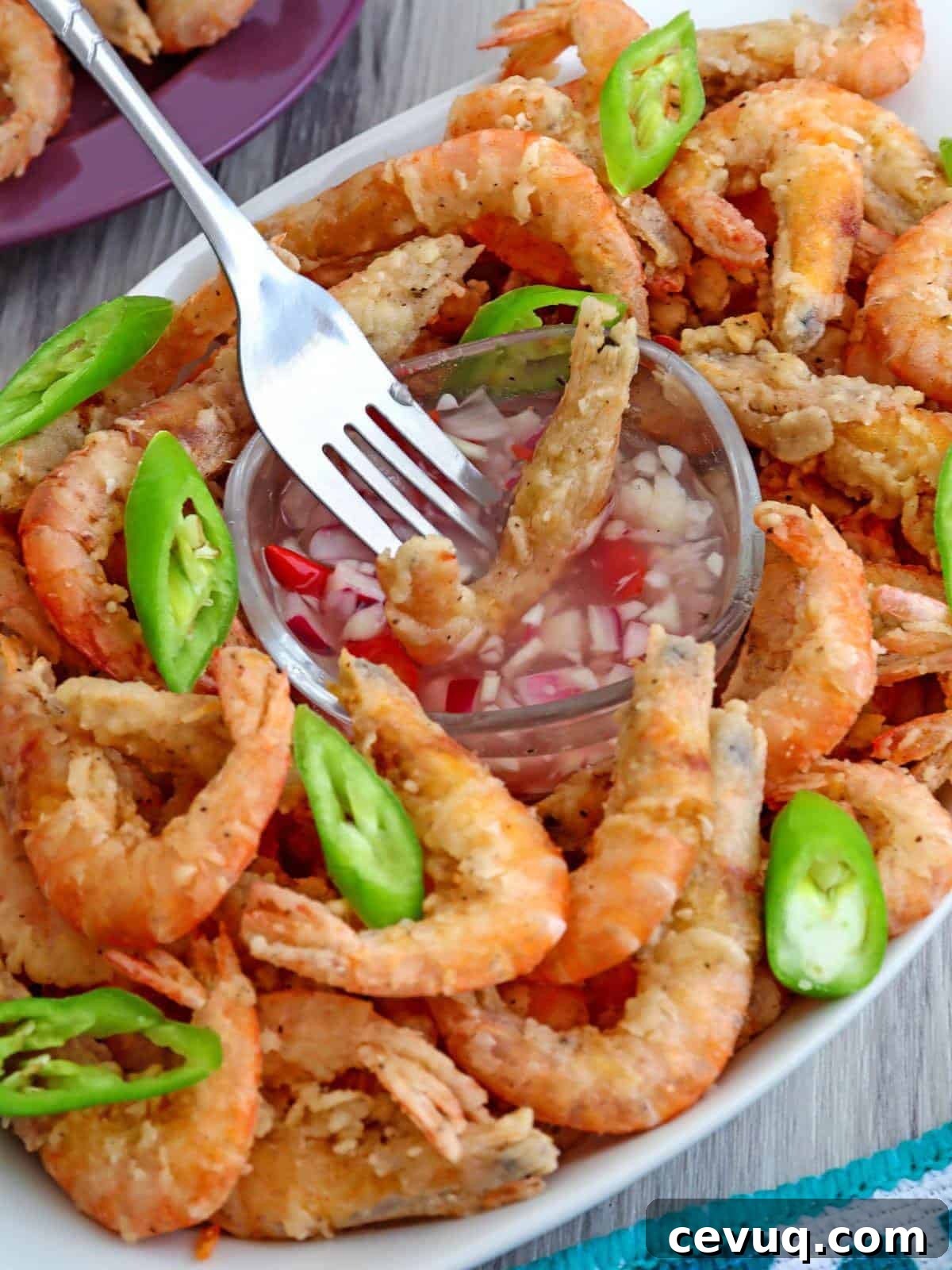 dipping crispy fried drunken shrimp in spicy vinegar