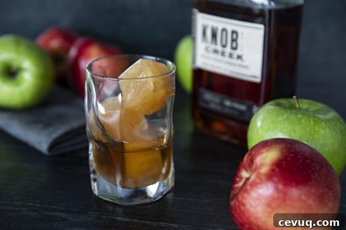 Glass of bourbon over apple cider ice cubes