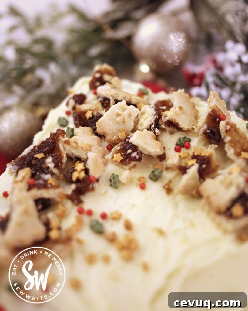 Mincemeat Cake: Festive Mince Pie Layer Cake Recipe 10 close up of broken mince pies on a cream cheese buttercream topped mincemeat cake with Christmas sprinkles