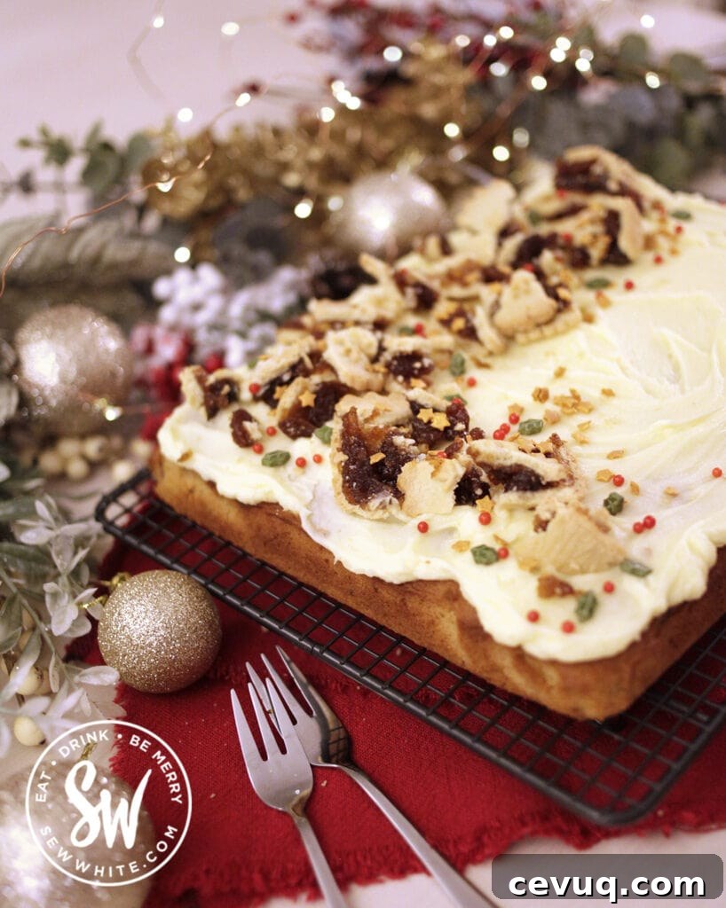 Mincemeat Cake: Festive Mince Pie Layer Cake Recipe 11 Christmas mincemeat sponge cake on a cooling rack with christmas foliage in the background.
