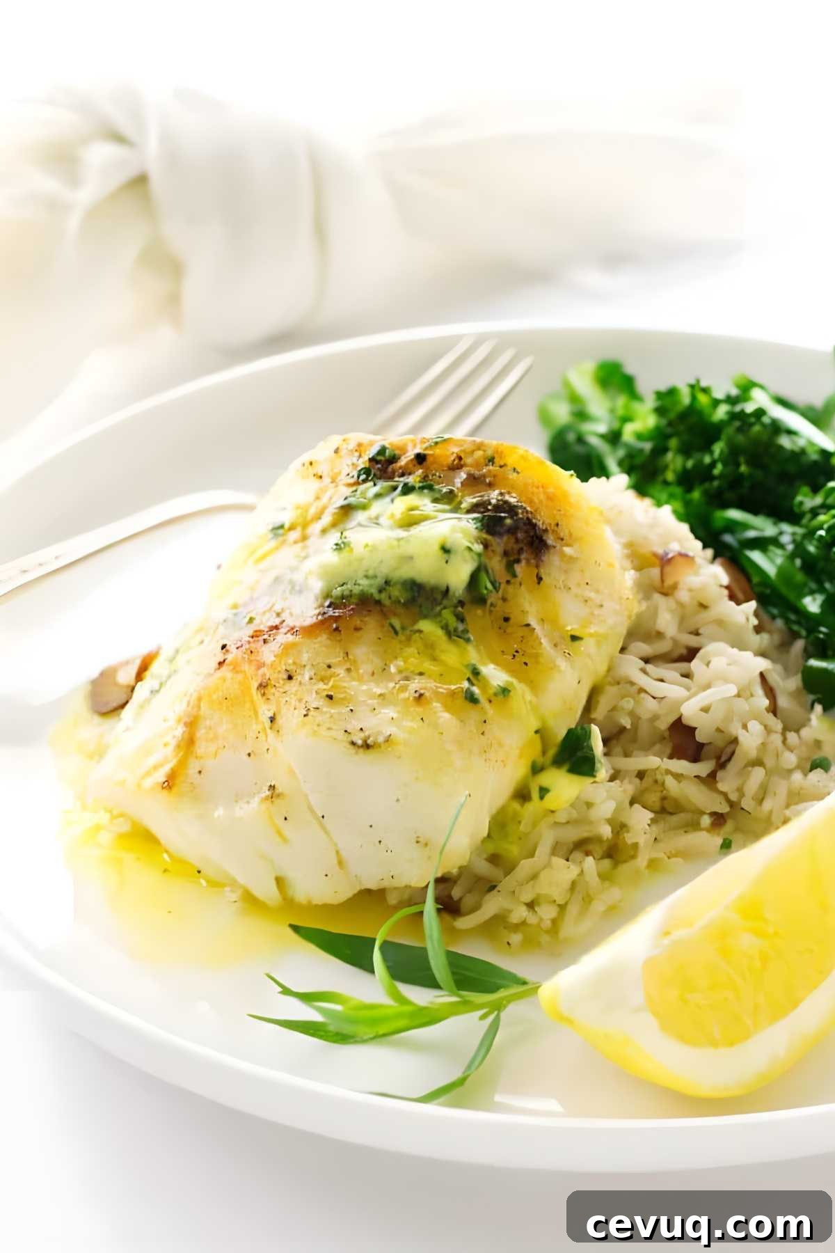 Broiled cod with herb butter on rice pilaf, greens, and lemon.