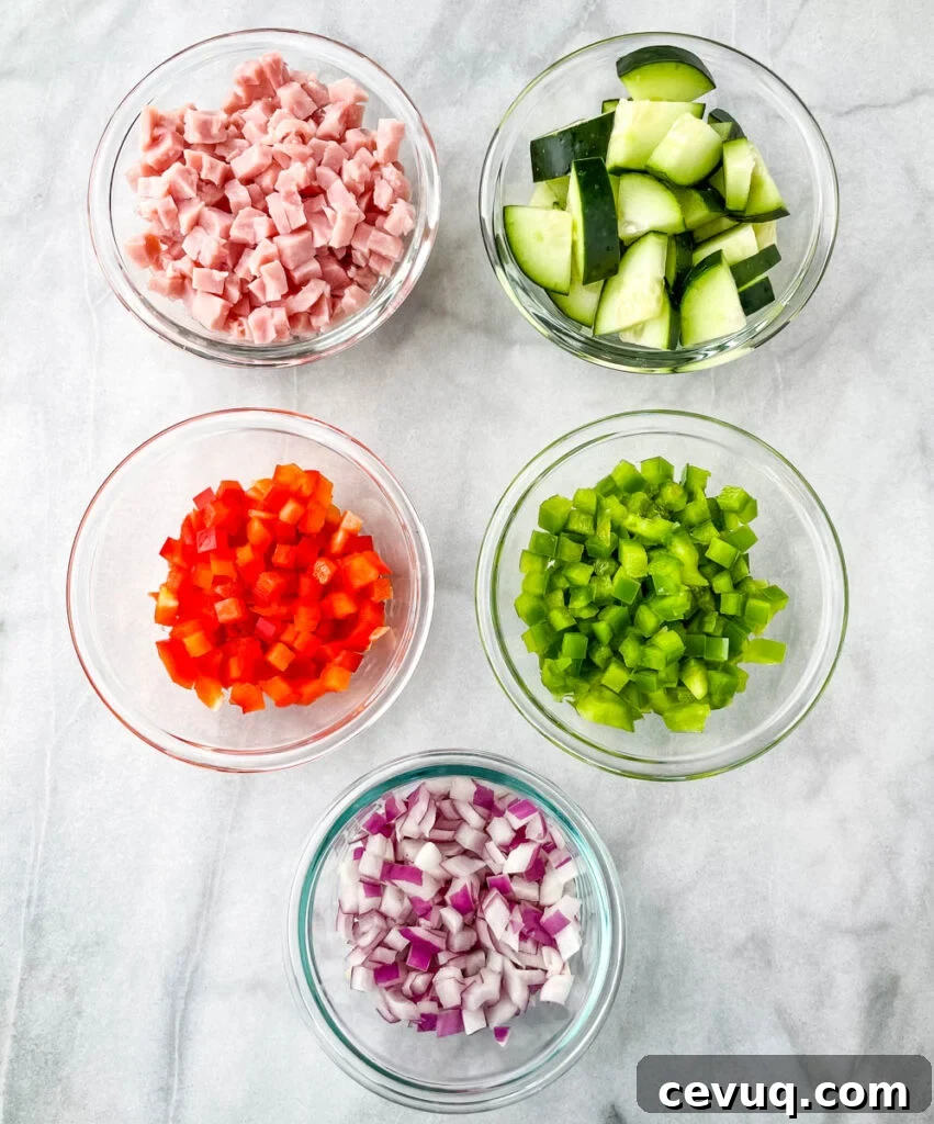 chopped ham, cucumbers, red peppers, green peppers, and red onions in separate bowls