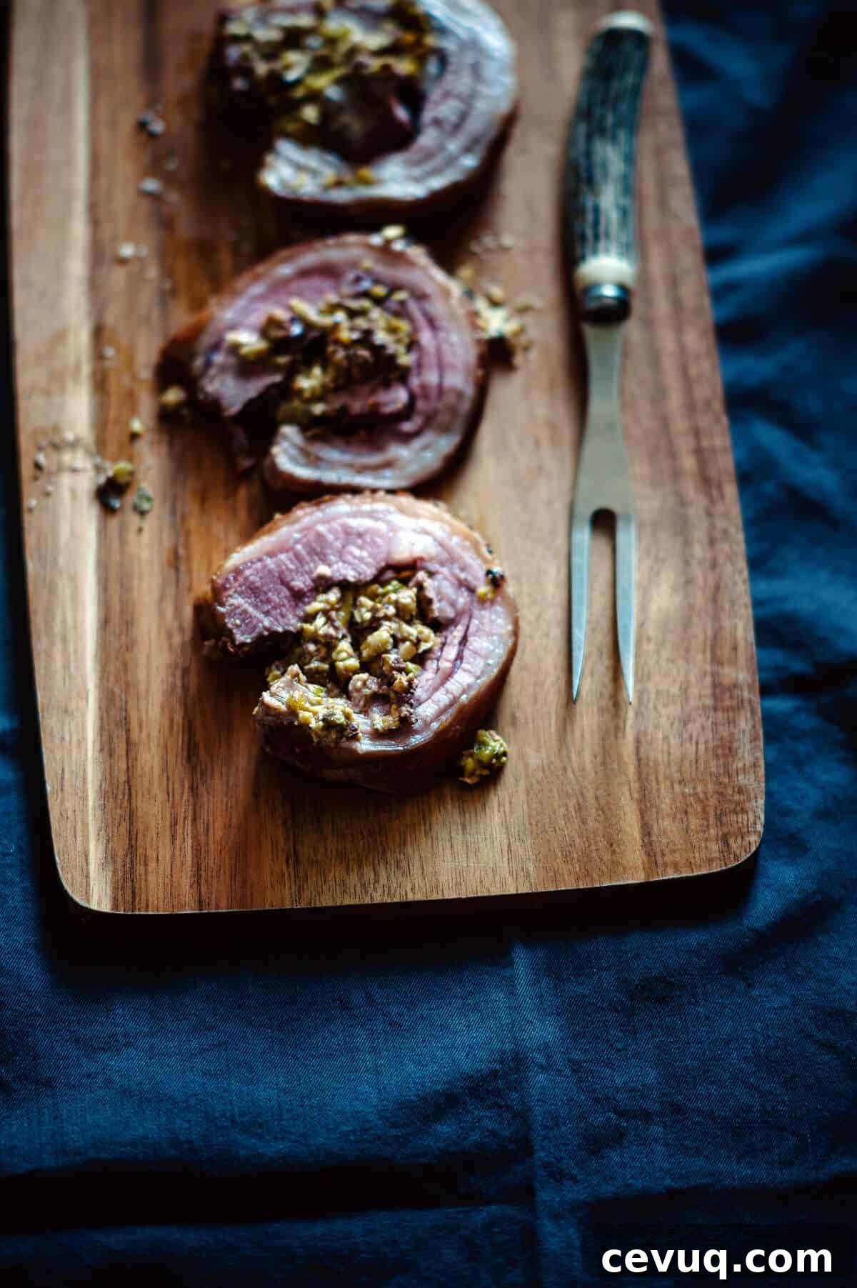 three slices of cooked lamb loin on a board
