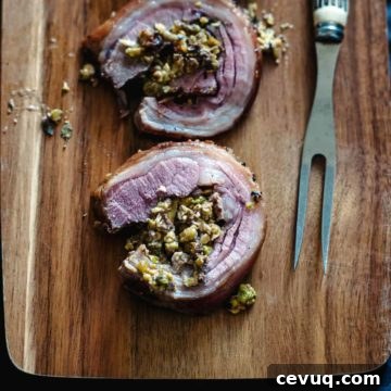 two slices of roasted lamb loin served on a wooden board