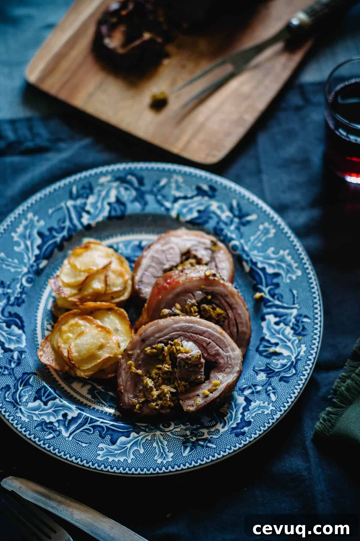 roast lamb served on a blue plate with a side of potatoes