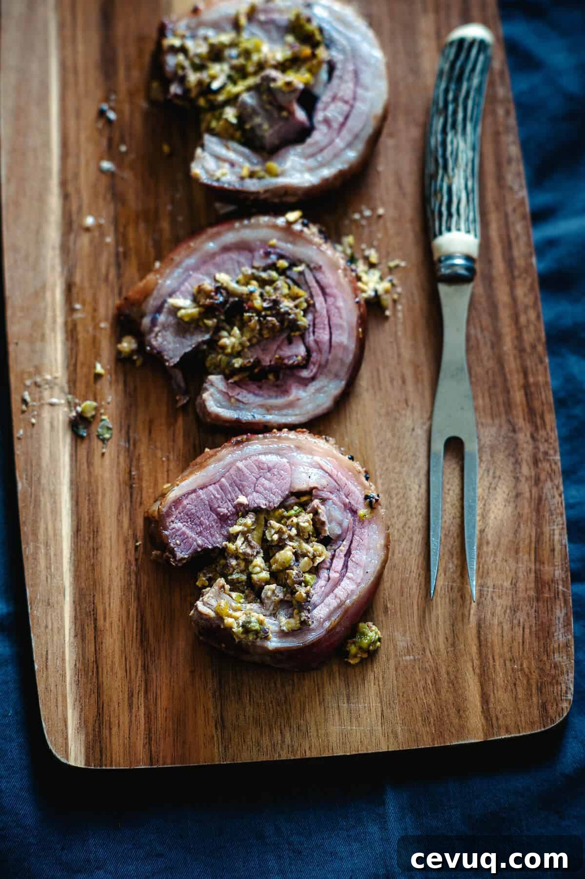 three slices of cooked lamb loin on a board