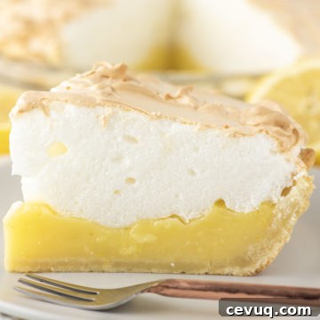 slice of lemon meringue pie with fork on plate