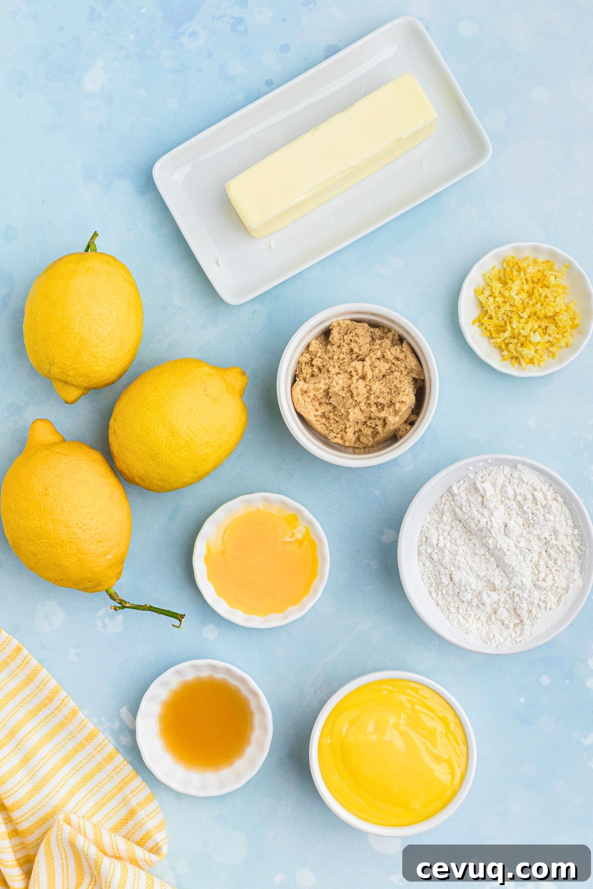 Ingredients needed to make lemon curd cookies, measured onto a light blue countertop.