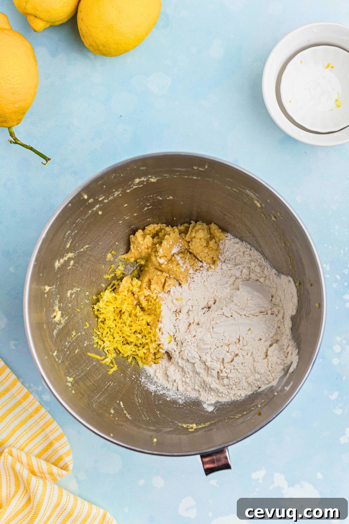 Cookie dough ingredients being mixed together in a silver mixing bowl. 