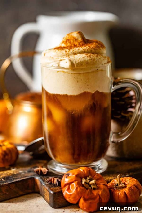 pumpkin cold foam in a cup on top of iced cold brew coffee.