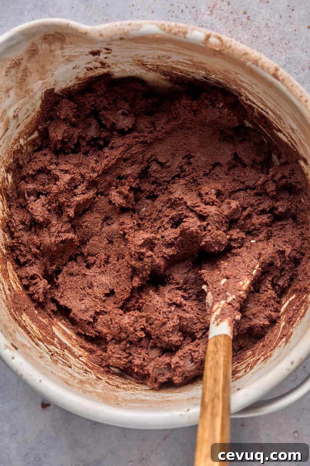 mexican hot chocolate cookie dough in a mixing bowl with a spatula.