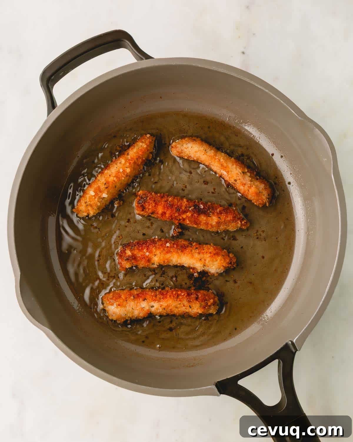 Cooked pork strips in a skillet.