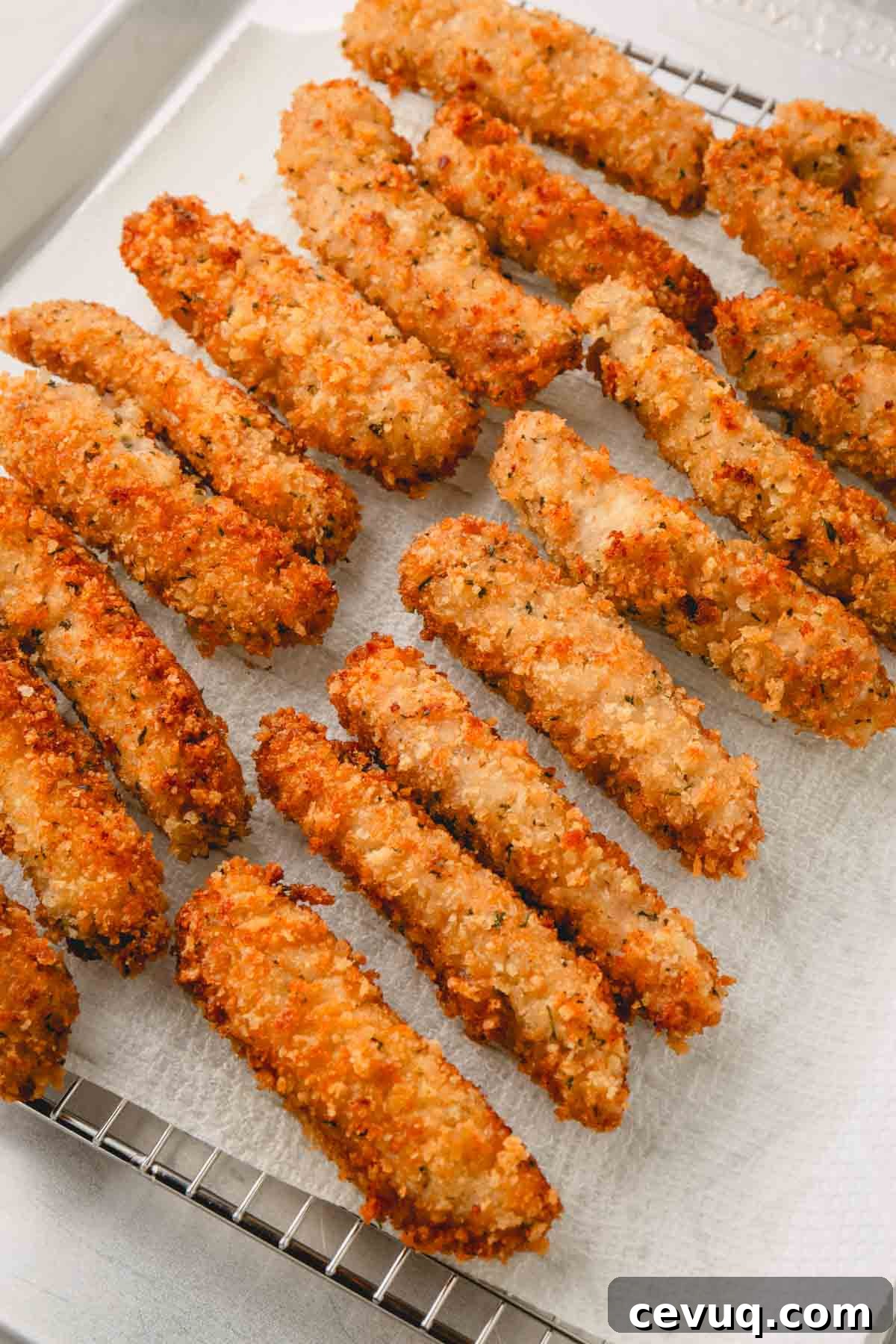 Fried pork strips draining on a paper towel. 
