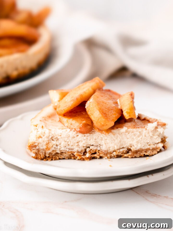 Slice of apple pie cheesecake on a plate.