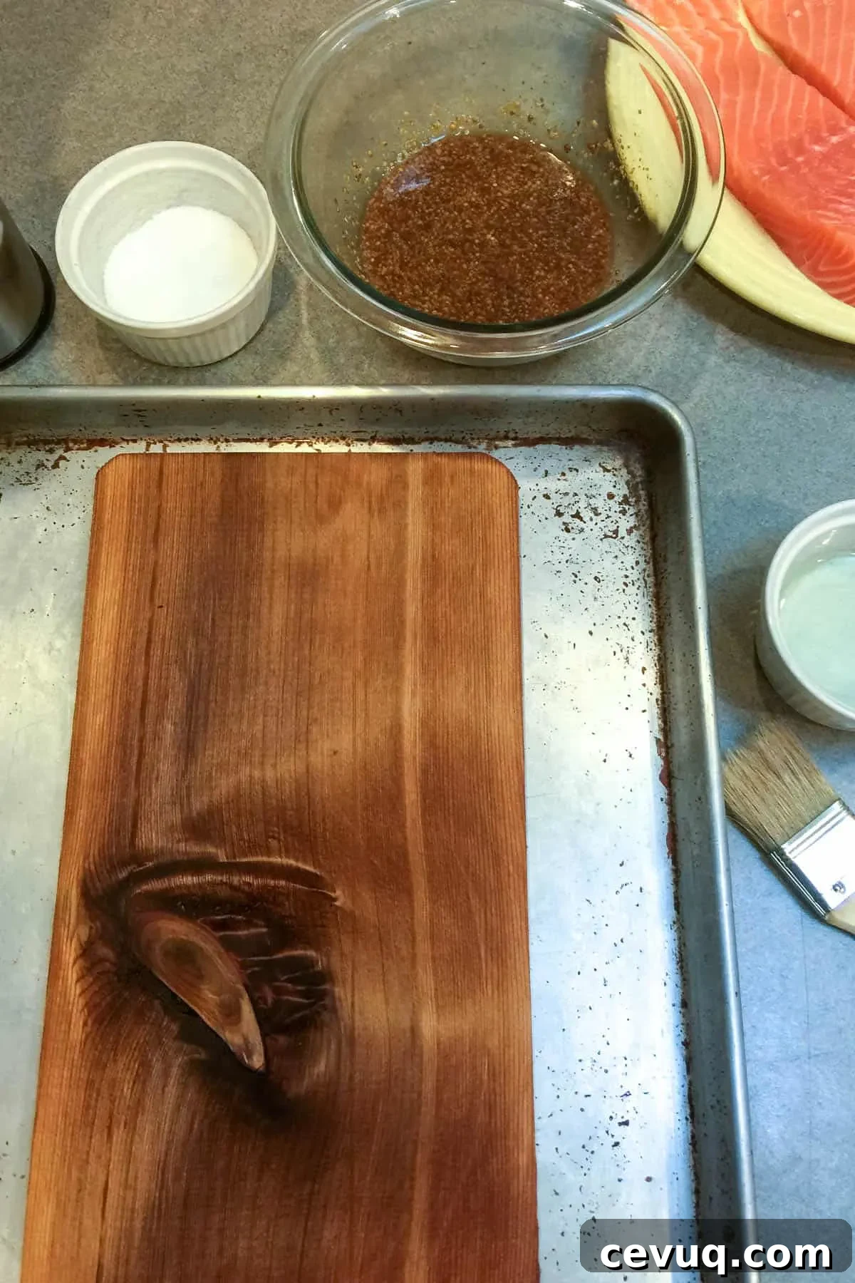 Soaked cedar plank on sheet pan ready for grill