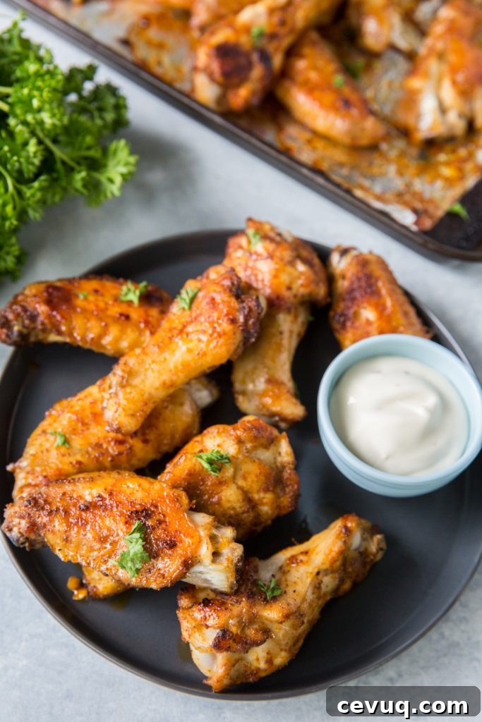 keto chicken wings on a plate with ranch topped with parsley 
