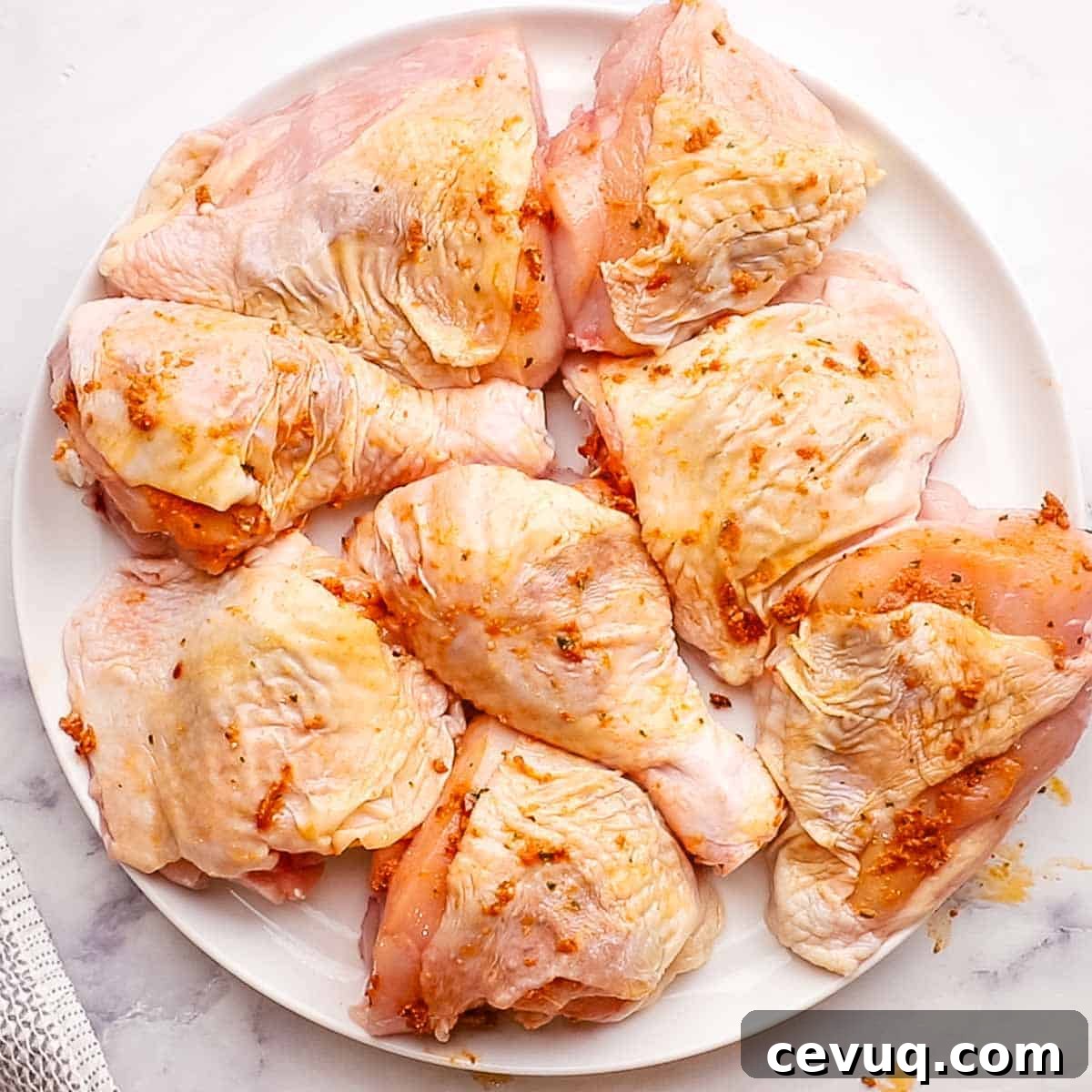 chicken thighs and drumsticks on a plate coated with sun dried tomato pesto