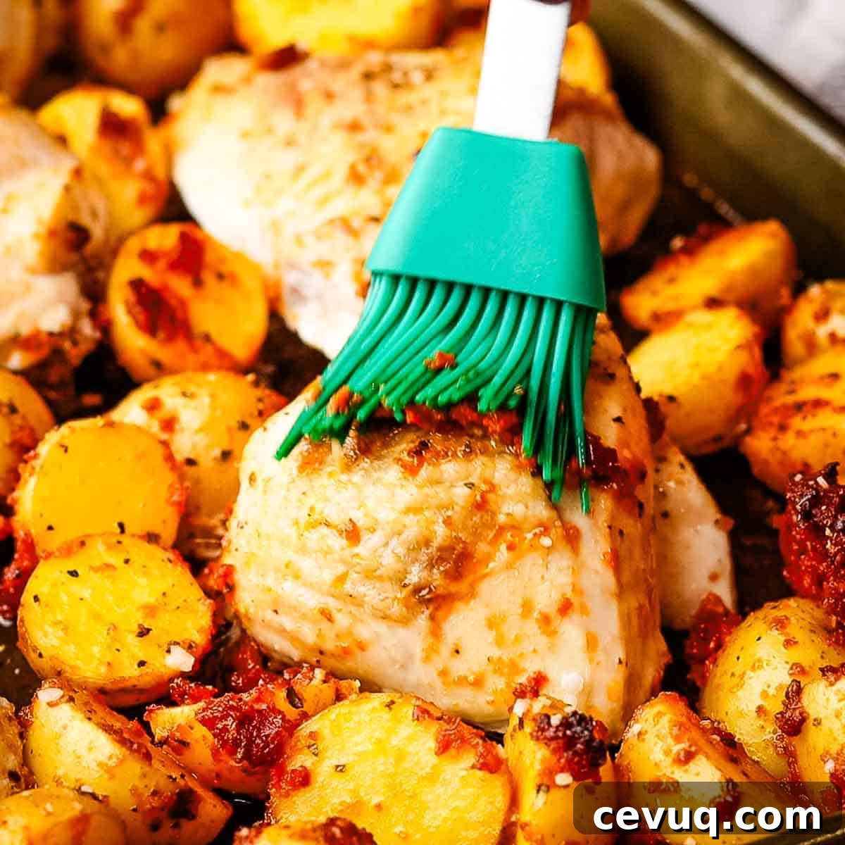 brushing more pesto on half done chicken