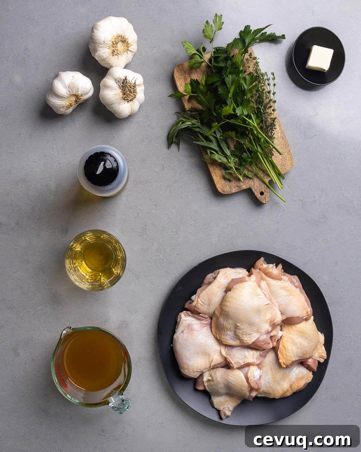 Garlic-Infused Roasted Chicken with 40 Cloves 4 Ingredients shown: garlic, parsley, tarragon, thyme, butter, olive oil, vermouth, chicken stock, and chicken thighs.