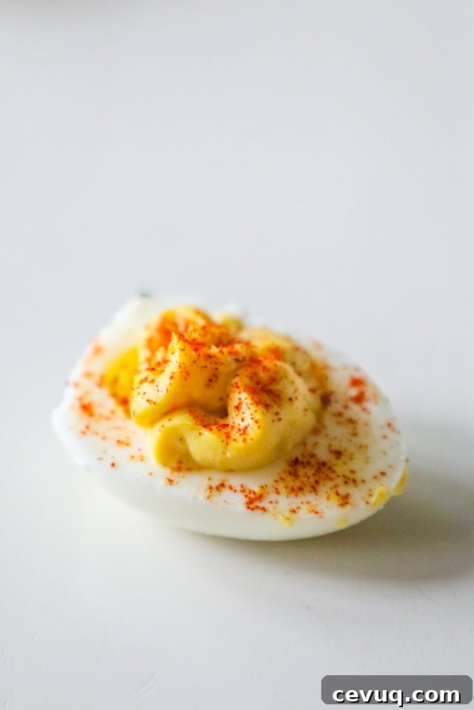 one deviled egg with paprika sprinkled on top on a table