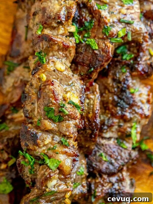 picture of lamb souvlaki on wooden cutting board with chopped cilantro on top