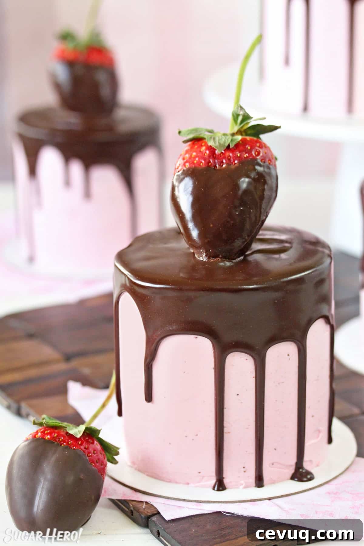 Chocolate-Covered Strawberry Mini Cake Recipe for Parties 2 Close-up of mini cake with pink strawberry buttercream, a chocolate drip, and a large chocolate strawberry on top.
