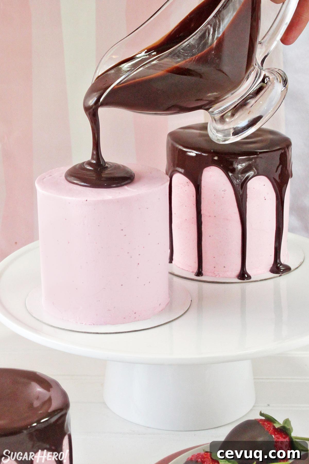 Chocolate-Covered Strawberry Mini Cake Recipe for Parties 5 Pouring shiny chocolate ganache on top of a pink-frosted miniature cake.