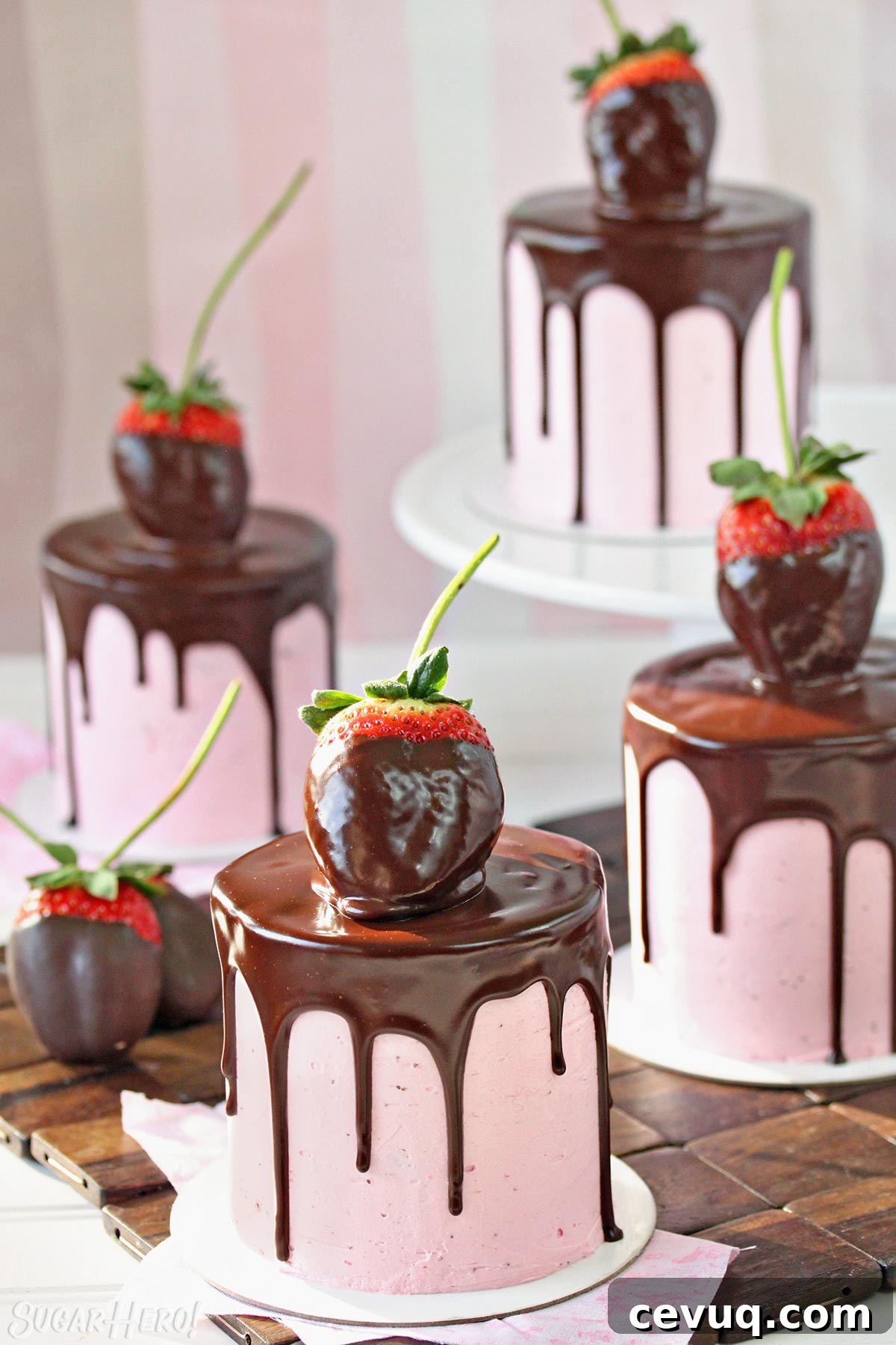 Chocolate-Covered Strawberry Mini Cake Recipe for Parties 7 Four mini chocolate cakes, covered with strawberry buttercream, a chocolate drip, and a chocolate-dipped strawberry on top.