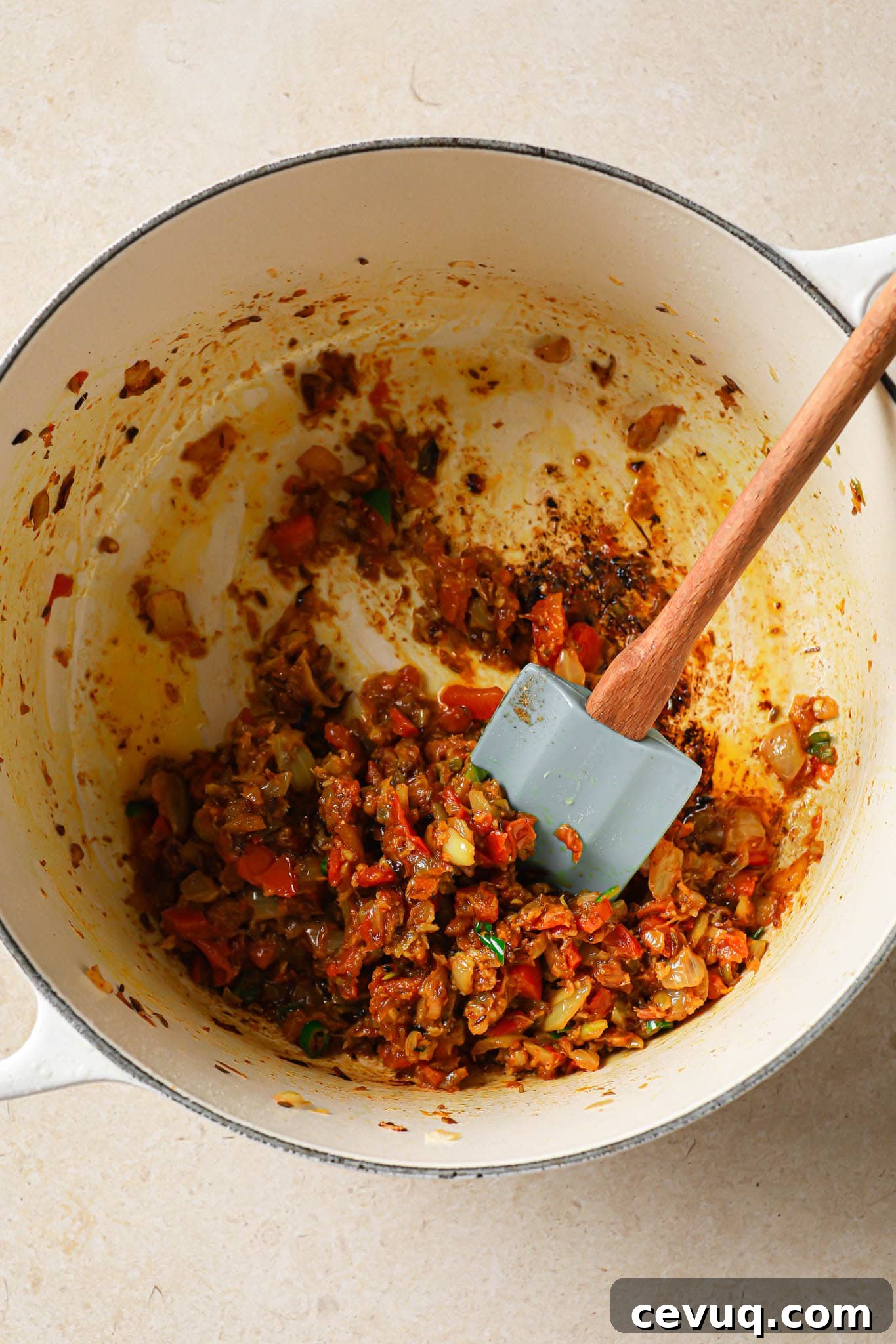 Adding tomatoes to browned onions.