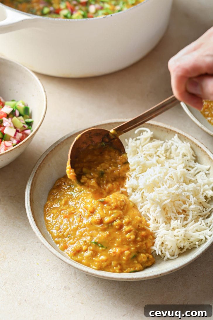 Scooping Masoor dal onto a bowl with rice.