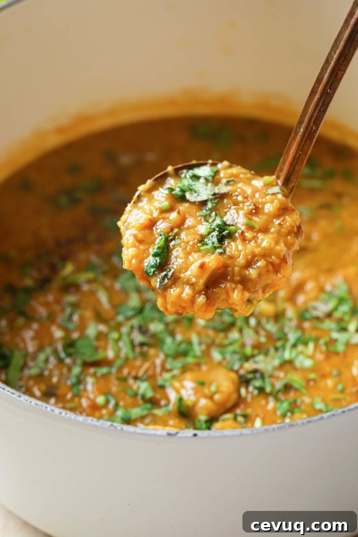 Scooping up Masoor Dal from a pot.