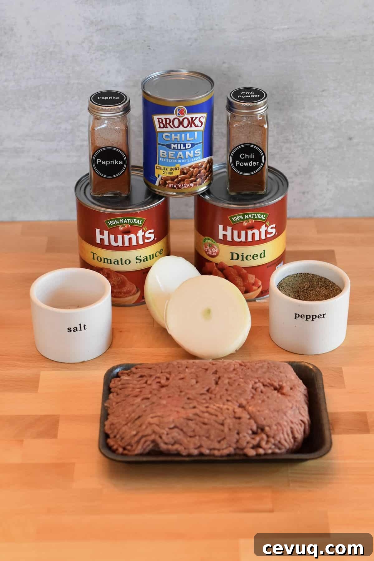 Ingredients for classic chili for a crowd including ground beef, beans, tomatoes, and spices.