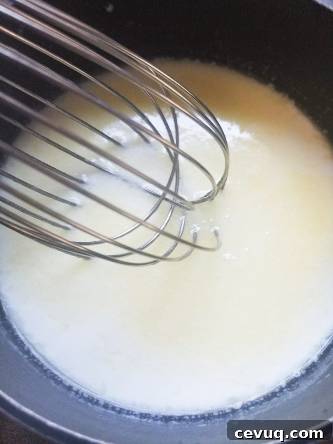 whisking alfredo sauce 