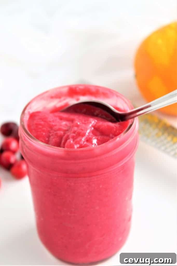 mason jar with cranberry curd and spoon