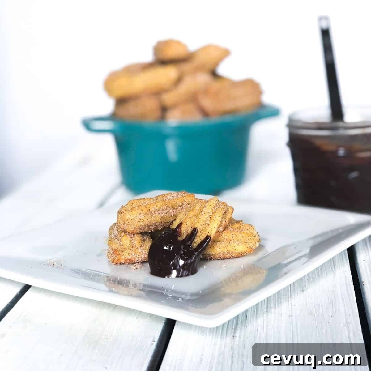 mini churro bites baked covered in chocolate sauce on a plate
