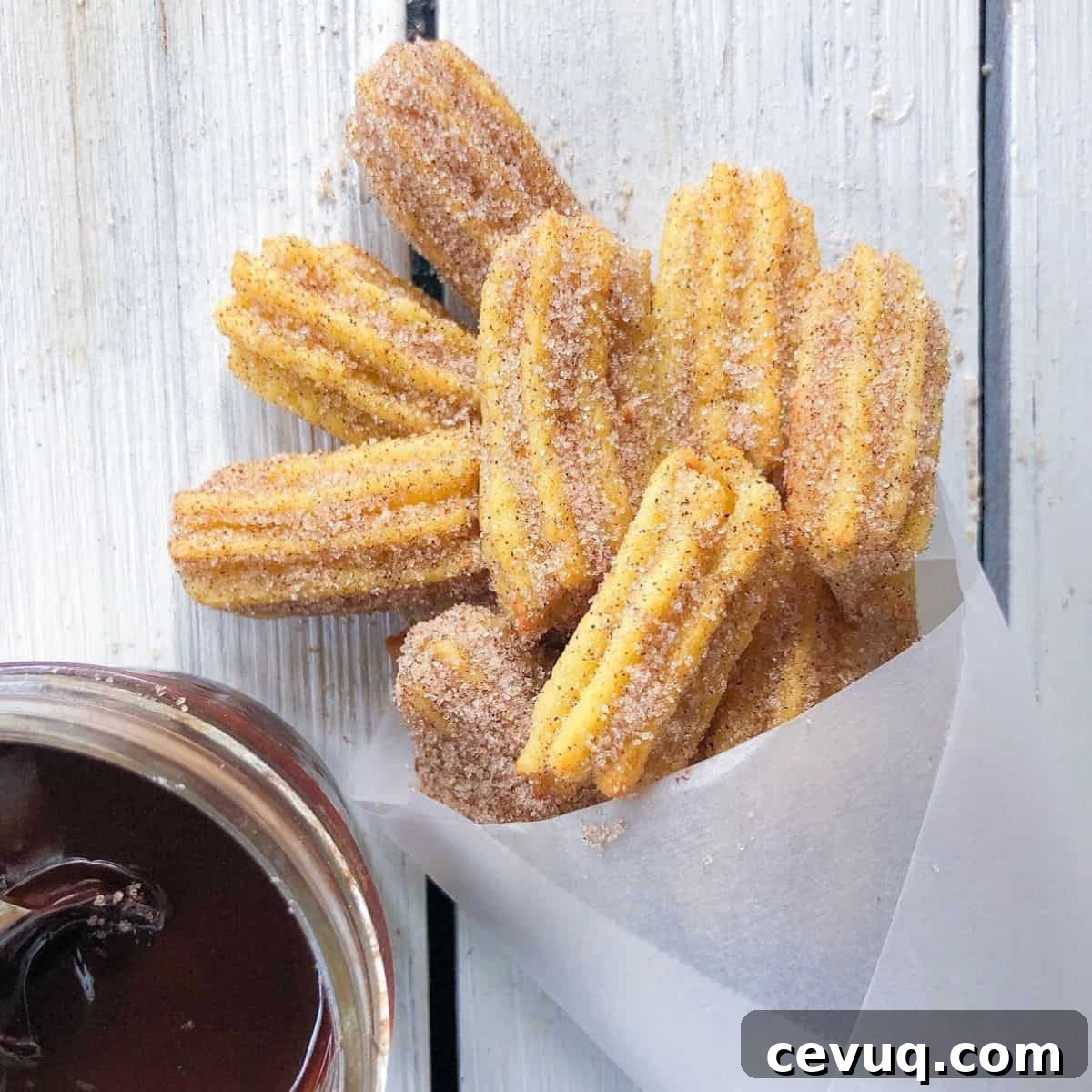 churros covered in cinnamon sugar with chocolate sauce on the side