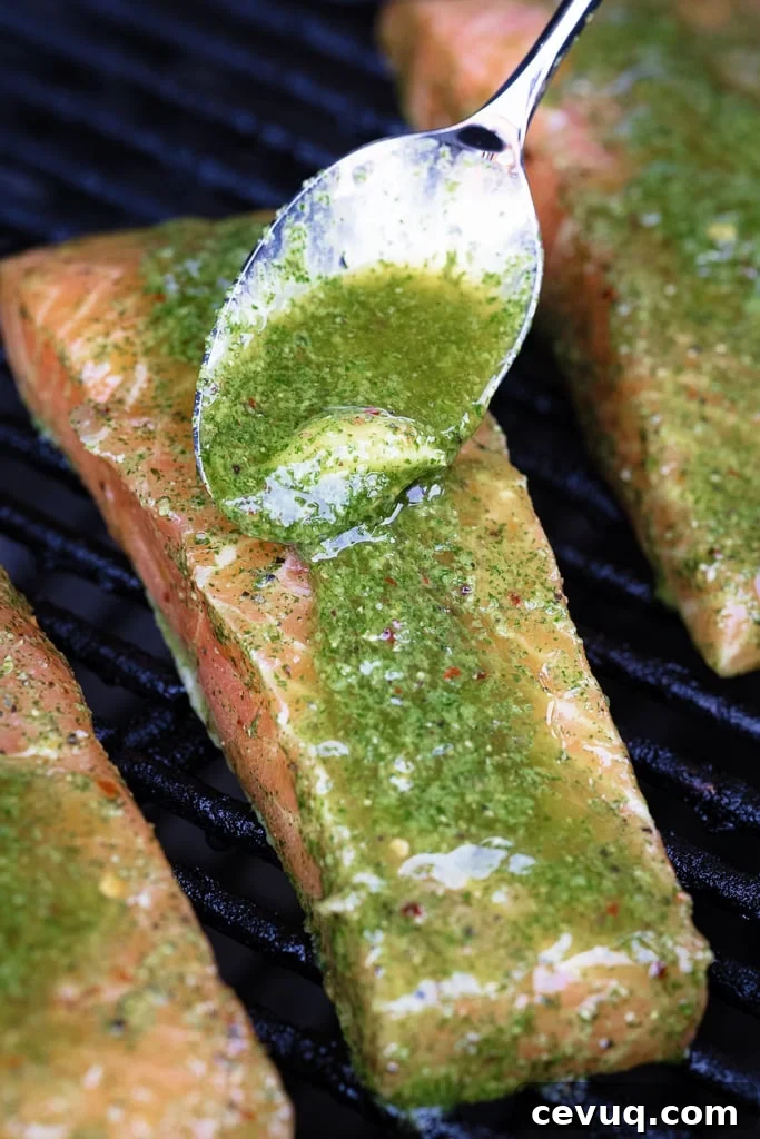 Cilantro lime marinade being spooned onto a salmon fillet on the grill