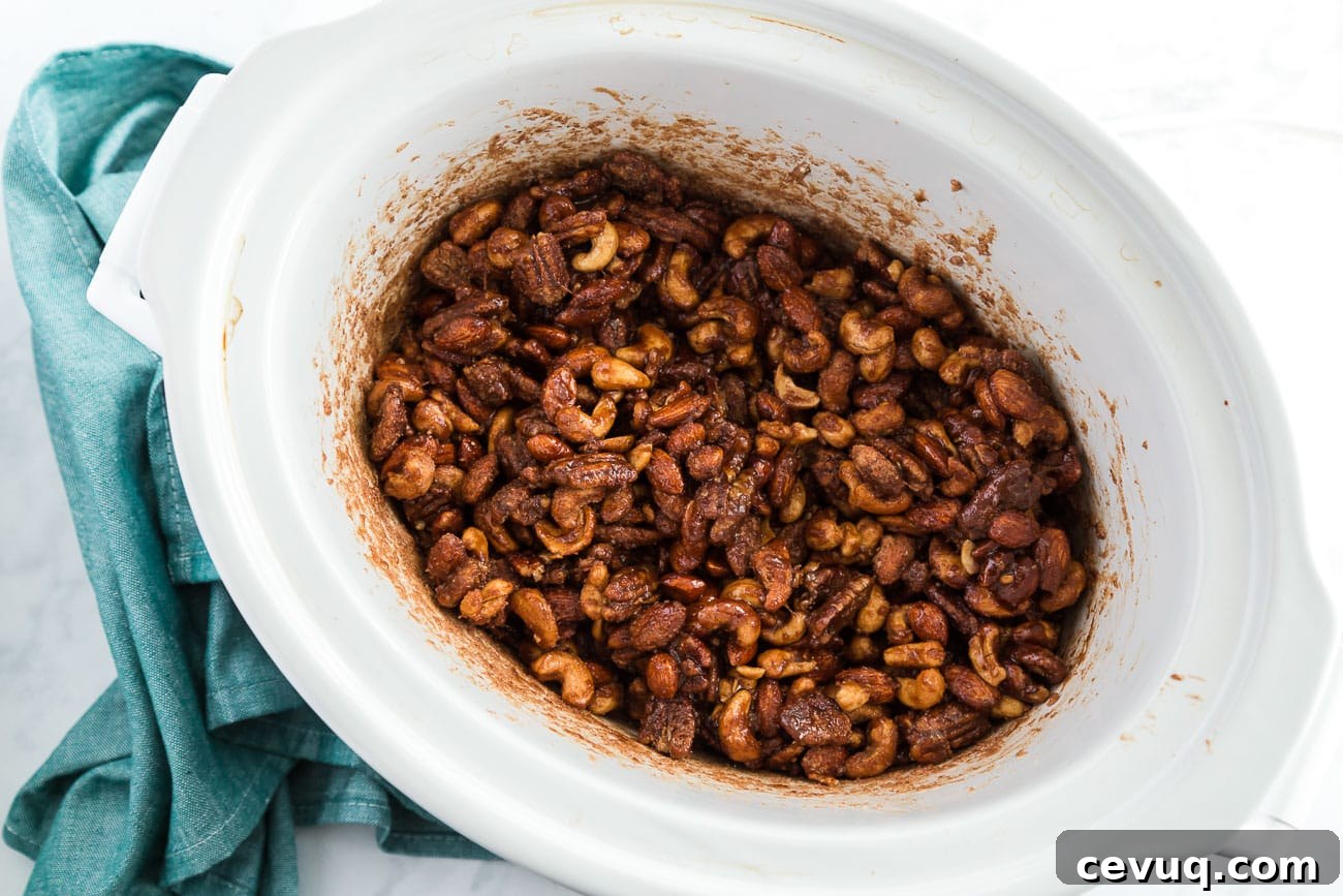 mixed nuts coated in cinnamon sugar inside a slow cooker