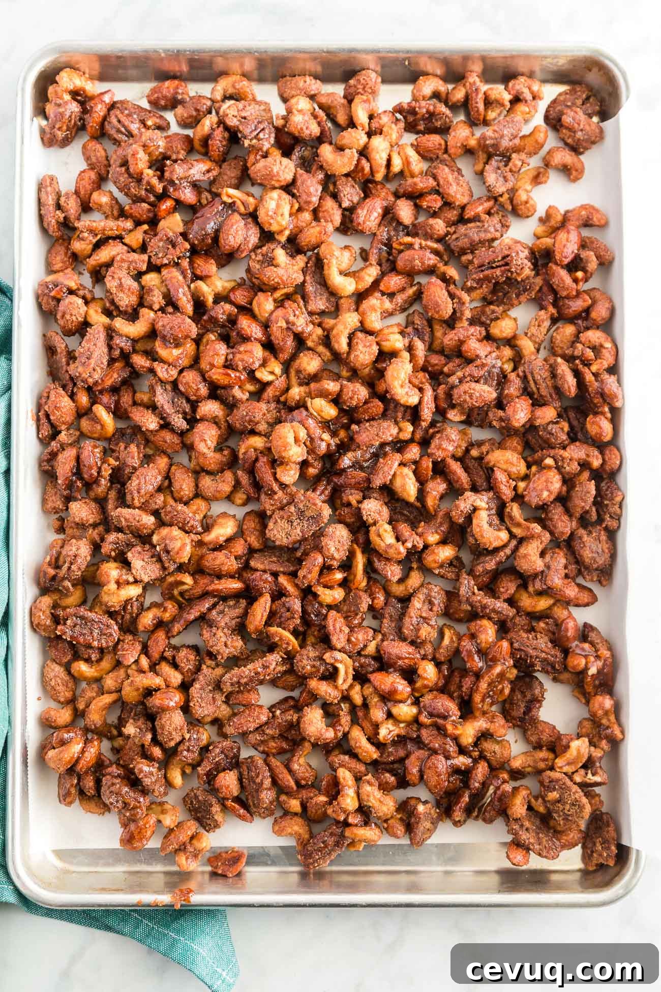 crock pot candied nuts cooling on parchment paper