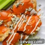 A plate filled with buffalo chicken thighs with blue cheese, ranch and celery.