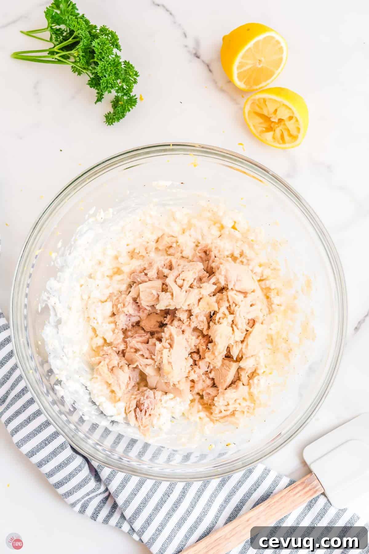 cans of tuna on top of cream cheese in a bowl