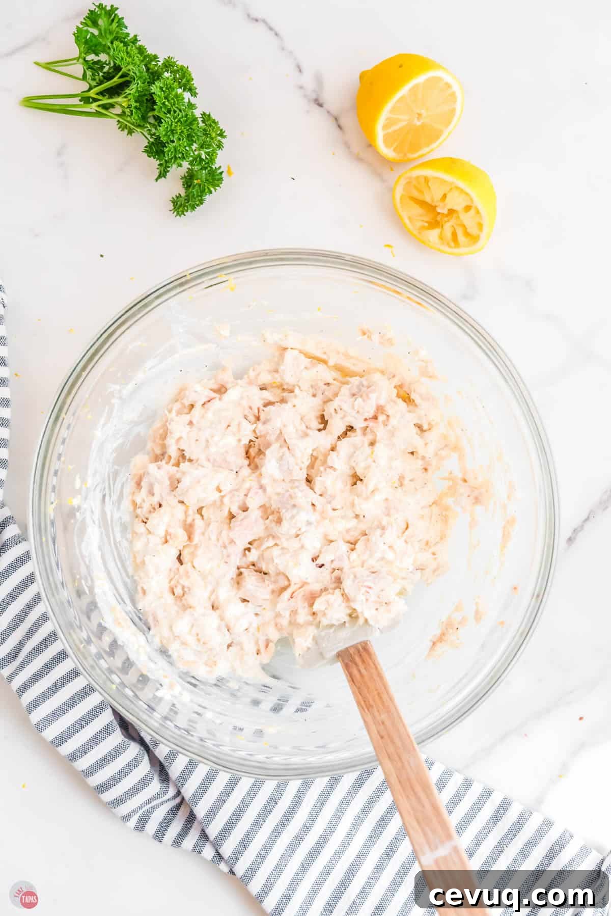 drained tuna being mixed with a spatula