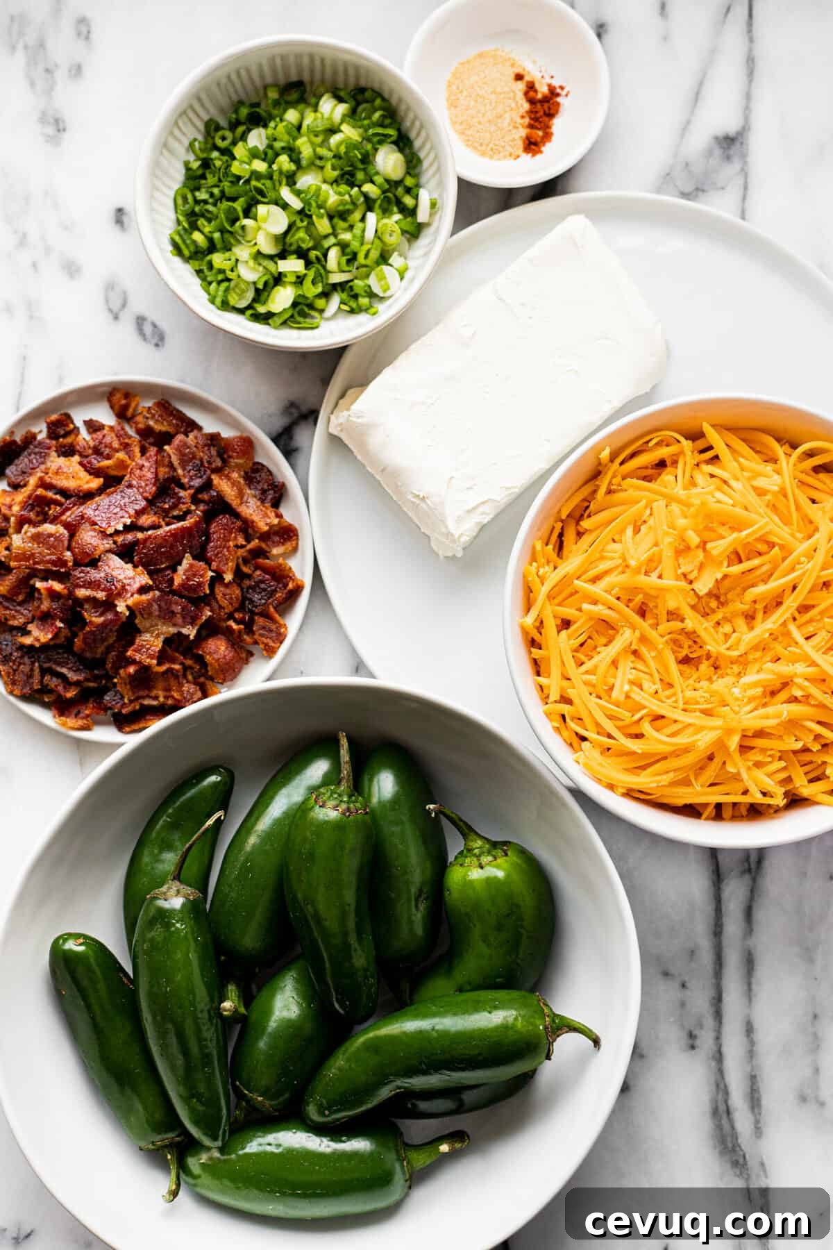 White counter top with bowls of ingredients to make air fryer jalapeno poppers.