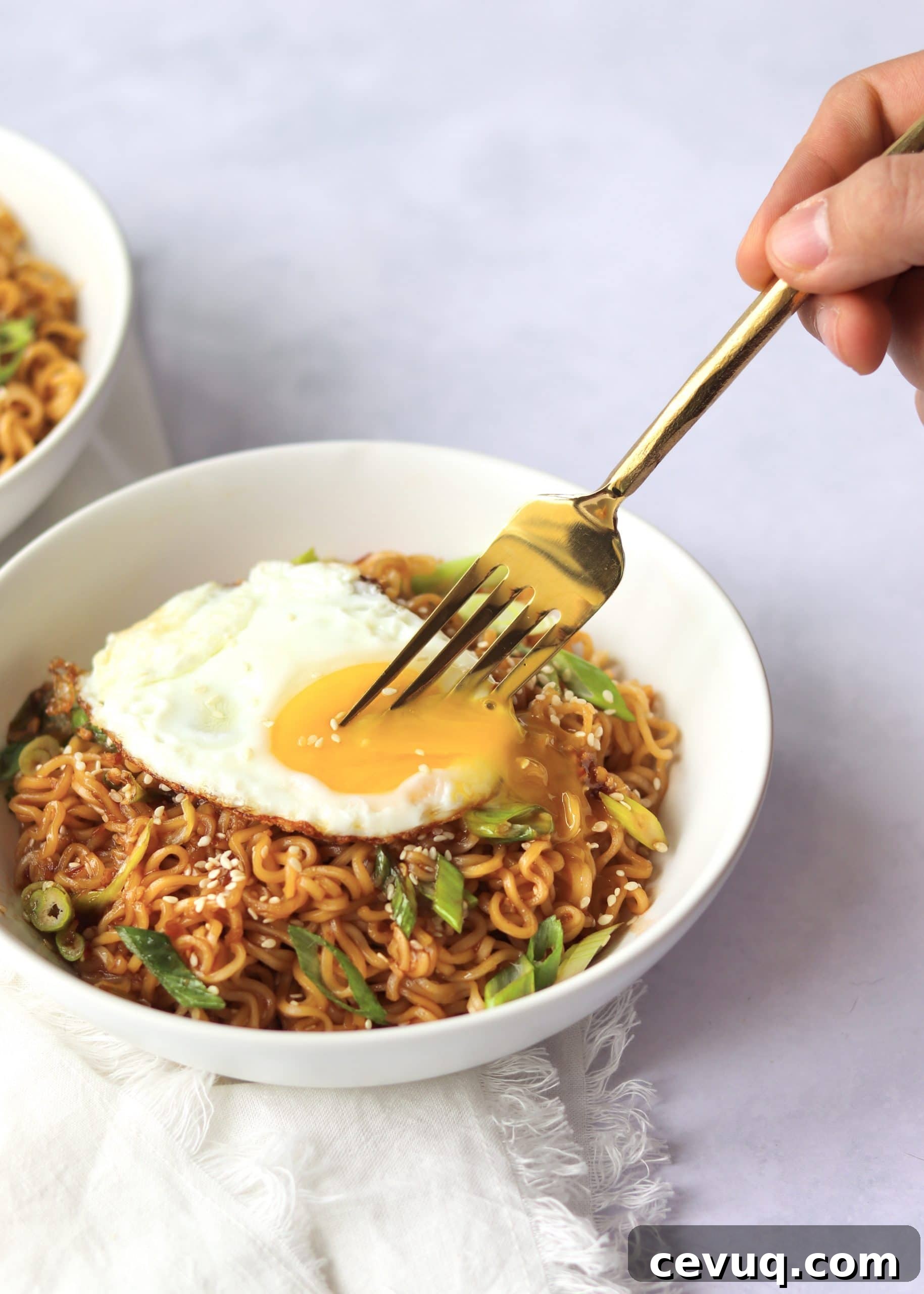Garlic Sesame Ramen for Two: Quick Homemade Recipe 6 Garlic sesame ramen noodles in bowl with egg on top and fork piercing yolk